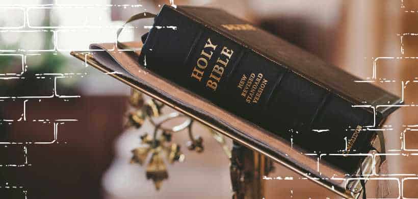una biblia negra acostada sobre un pulpito
