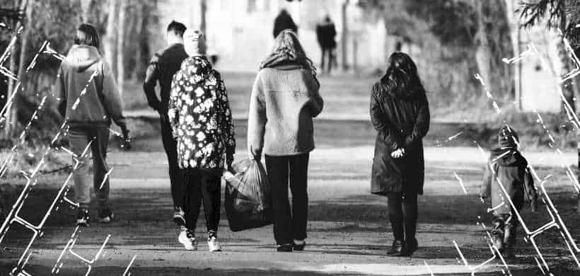 una familia de 6 personas caminando en un parque, blanco y negro