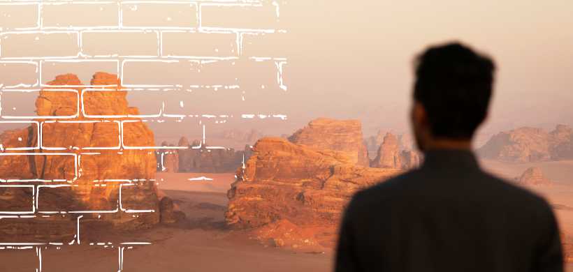 un hombre mirando hacia un desierto con montañas